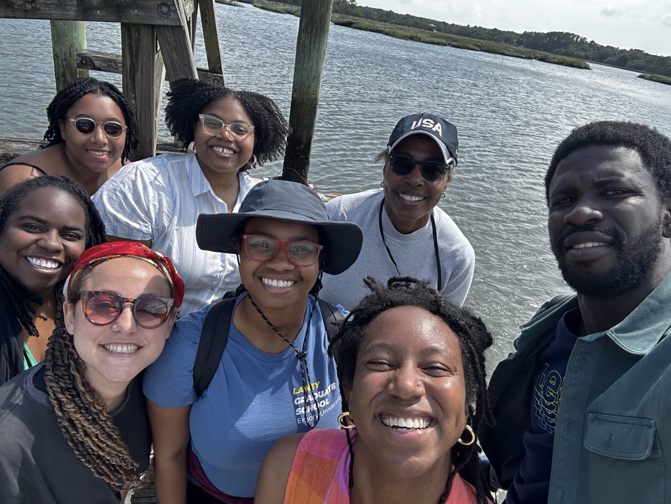 Valerie Babb with summer scholars of the “Culture and Community at the Penn Center National Historic Landmark District” program. Babb and students stand on the Retreat House dock, Penn Center, St. Helena Island, South Carolina. Water and land can be seen in the background.